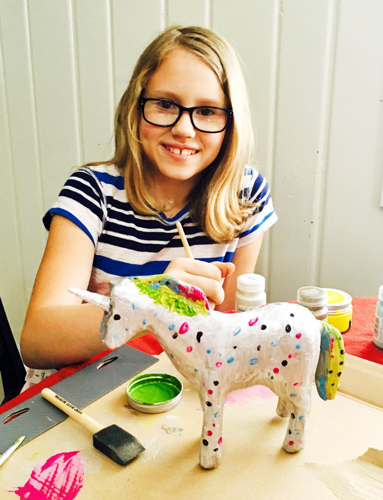 Hannah painting a paper mache unicorn with materials from Target!