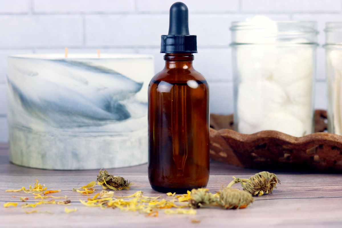 DIY calendula face oil recipe with essential oils for beautiful glowing skin. Get acne free skin that looks flawless and enjoy the skin care benefits of calendula for face. This easy, natural anti-aging green beauty recipe moisturizes and nourishes skin to prevent acne and reduce the signs of aging as part of your clean beauty regimen. Craft your own DIY calendula face oil customized with essential oils for your skin type as an easy plant based beauty recipe for anti-aging natural skin care.