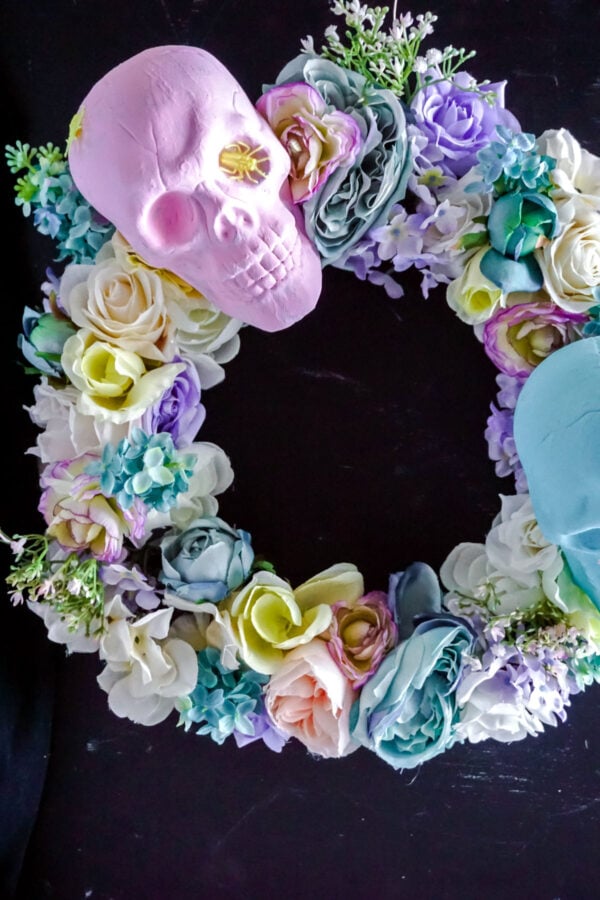 Dollar Tree DIY Halloween Wreath. How to make a DIY Halloween Skull Wreath with pastel painted skulls to decorate your front door for Halloween holiday home decor on a dime. This Dollar Tree DIY Halloween Wreath is inexpensive and easy to make for chic Halloween decorations for your home. This Dollar Store DIY Halloween wreath idea offers a beautiful take on a normally macabre element and utilizes Dollar Tree Halloween supplies to save you money on your seasonal holiday Halloween decor.